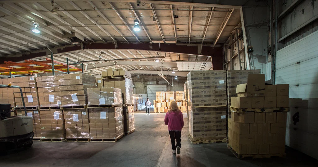 Tarimas con cajas de cartón acomodadas en el piso de un centro de distribución