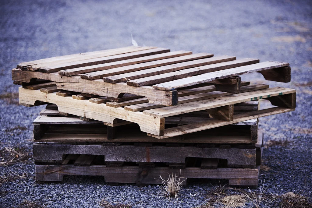 Tarimas de madera vacías apiladas unas sobre otras sobre el piso